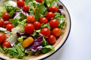 Lezzetli vejetaryen kırmızı ve sarı kiraz domates, roka, lahana ve marul salatası