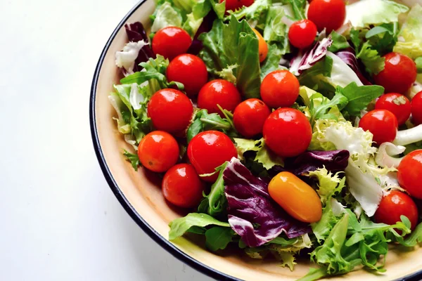 Chutný vegetariánský salát s červenými a žlutými cherry rajčátky, rukolou, zelí a salát — Stock fotografie