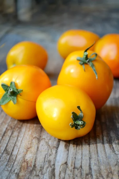 Big yellow tomatoes on old wooden background — Stock Photo, Image