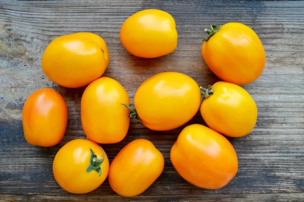 Große gelbe Tomaten auf altem Holzgrund — Stockfoto