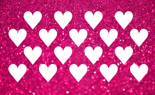 Lots of white hearts over bright and abstract blurred pink background with shimmering glitter — Stock Photo, Image