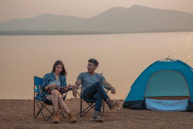 Çiftler tatilde göl kenarında kamp yapar ve piknik yaparlar.