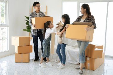 Hareketli günde yeni evde karton kutular ile Mutlu Asya aile