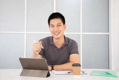 Ofiste dizüstü bilgisayarla çalışan Asyalı iş adamı