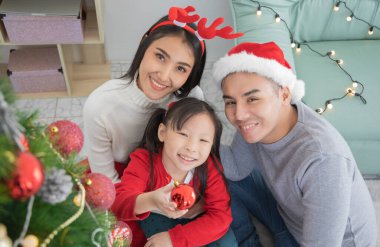 Mutlu Noeller ve Mutlu Noeller Sevgi dolu aile. Baba ve çocuk evde Noel ağacı süslüyorlar.