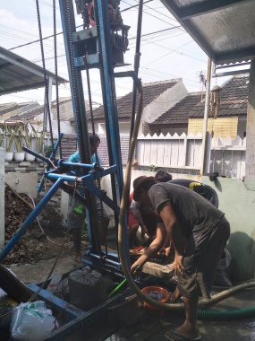 Profesyonel işçiler temiz su için kuyu kazıyor.