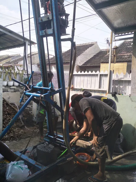 Profesyonel işçiler temiz su için kuyu kazıyor.