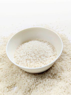 Beyaz kase içinde kuru beyaz pirinç tohumları.