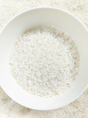 Beyaz bir kase içinde taze yasemin pirincinin en üst görüntüsü.