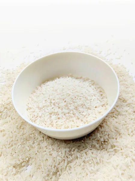 Beyaz kase içinde kuru beyaz pirinç tohumları.