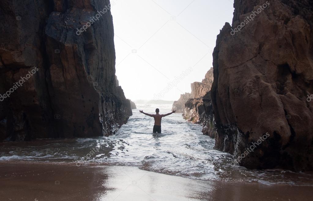 Man Raising His Hands between high rocks
