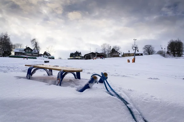 雪の降る冬の国のバック グラウンドでスキー場のリフトと青い子供そり — ストック写真