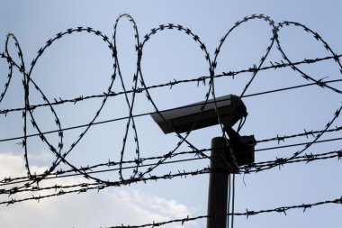 Güvenlik kamera arkasında dikenli tel çit hapishane duvarları
