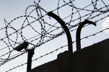 Güvenlik kamera arkasında dikenli tel çit hapishane duvarları