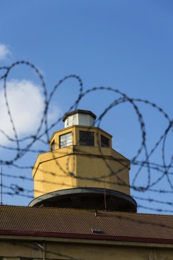 Hapishane duvarları etrafında dikenli tel çit arkasındaki Koruma Kulesi