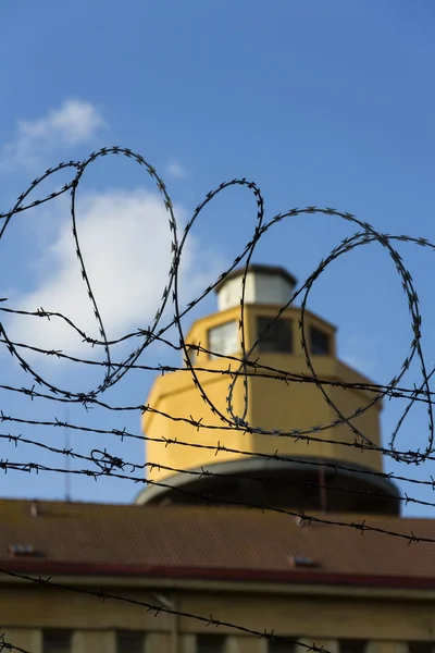 Őrző-védő torony mögött szögesdrót kerítés körül börtön falai — Stock Fotó