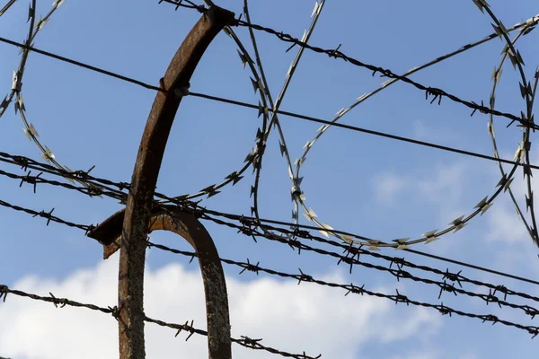 Gevangenis muur prikkeldraad hek met blauwe hemel in achtergrond — Stockfoto