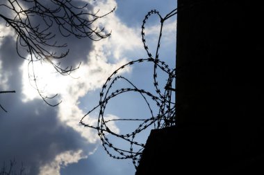 Dramatik bulutların arkasında hapis duvar dikenli tel çit 