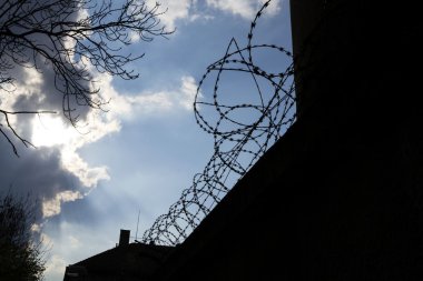 Dramatik bulutların arkasında hapis duvar dikenli tel çit 
