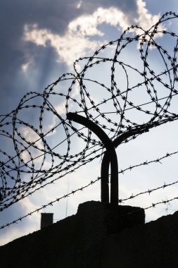 Dramatik bulutların arkasında hapis duvar dikenli tel çit 