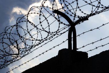 Dramatik bulutların arkasında hapis duvar dikenli tel çit 