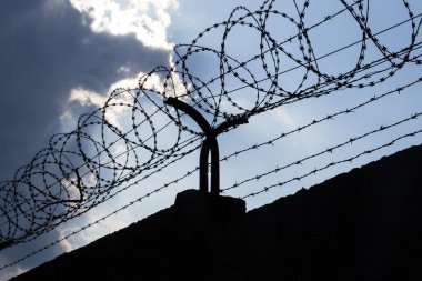 Dramatik bulutların arkasında hapis duvar dikenli tel çit 