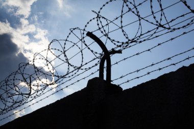 Dramatik bulutların arkasında hapis duvar dikenli tel çit 