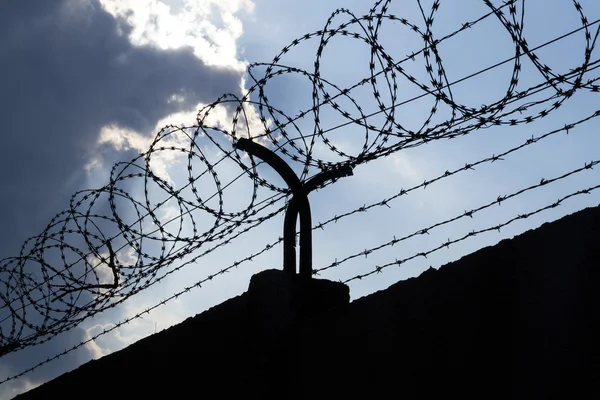Dramatik bulutların arkasında hapis duvar dikenli tel çit 