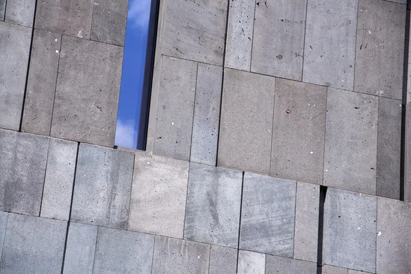 Ventana estrecha que refleja el cielo azul en el exterior moderno edificio de oficinas de hormigón —  Fotos de Stock