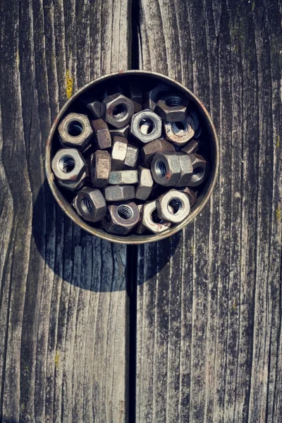 Noten in een blikje op houten plank achtergrond — Stockfoto