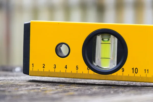 Bubble spirit water level construction tool on wooden board close-up