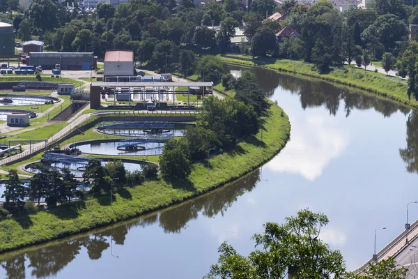 Widok z lotu ptaka rzeki wije się wokół oczyszczalni wody — Zdjęcie stockowe