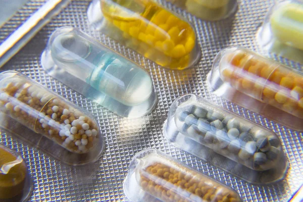 Λεπτομέρεια από διάφορα πολύχρωμα χάπια σε διαφανή ιατρικής κάψουλα — Φωτογραφία Αρχείου