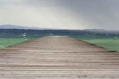 Dalgalar üzerinde Lago di Garda, Sirmione, İtalya ile ahşap iskele