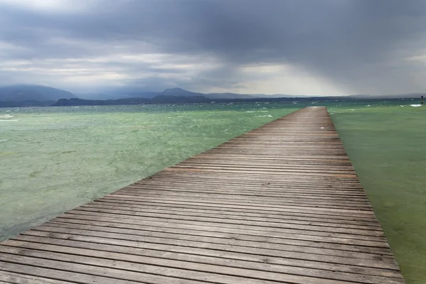 Dalgalar üzerinde Lago di Garda, Sirmione, İtalya ile ahşap iskele — Stok fotoğraf