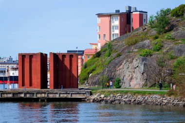 İnsanlar 13 Mayıs 2025 'te İsveç' in Göteborg şehrinde Eriksberg ve Slottsberget arasındaki Rüzgâr Tapınağı Vindarnas Tempel 'de yürür..