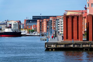 İnsanlar 13 Mayıs 2025 'te İsveç' in Göteborg şehrinde Eriksberg ve Slottsberget arasındaki Rüzgâr Tapınağı Vindarnas Tempel 'de yürür..