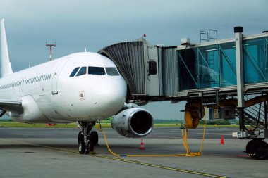 Havaalanı pistinde uçağa bağlı jet biniş köprüsü ile uçuş hazırlığı.