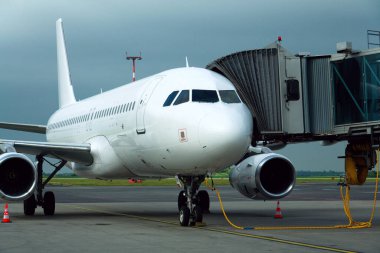 Havaalanı pistinde uçağa bağlı jet biniş köprüsü ile uçuş hazırlığı.