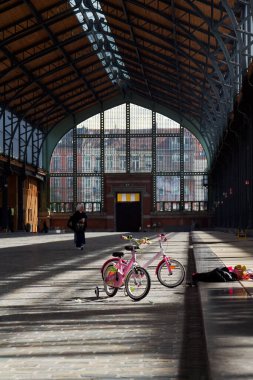 25 Mayıs 2025 'te Brüksel, Belçika' da Tur ve Taksi sahasındaki Gare Maritime eski tren istasyonunda duran iki üç tekerlekli bisiklet..