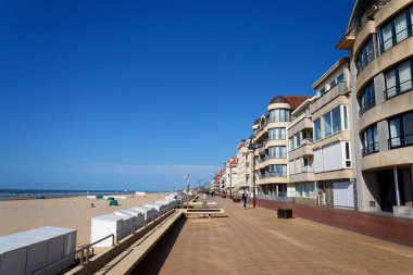 23 Mayıs 2025 'te De Haan, Belçika' da, güneşli bir yaz gününde Batı Flanders 'daki sahil köyünde rıhtımda yürüyen insanlar..