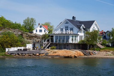 Alvsborgsfjorden limanının kıyısındaki Saltholmen yarımadasındaki kayalıklarda evler, Alvsborg ilçesi, güneşli bir gün, Gothenburg, İsveç