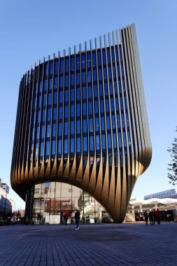 Masarycka MSD Masaryk İstasyon Geliştirme Ofisi ve Zaha Hadid Mimarlar tarafından 19 Kasım 2025 'te Çek Cumhuriyeti Prag' da altın cepheli perakende binası.