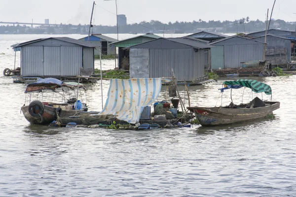 Ratty boats and raft houses with fish cages floating on Mekong river — Stock Photo, Image
