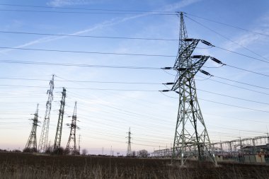Elektrik direkleri dağıtım güç istasyonu ile bulutlu gökyüzü mavi