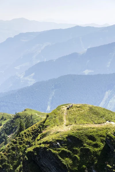 牧歌的な夏オーストリアのアルプス山脈の景色と木製のベンチ — ストック写真