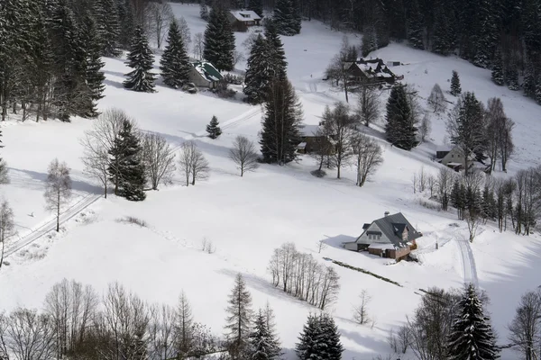 Морозна засніжена країна з будинками в сонячний зимовий день — стокове фото