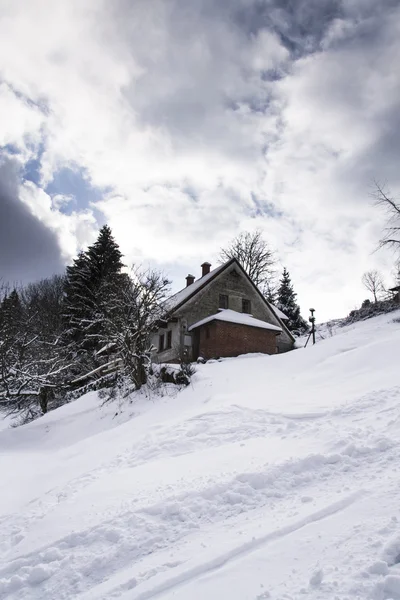 Casa coperta di neve in un paese di montagna gelido — Foto Stock