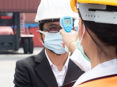 İş adamı yöneticisi Forman Mühendis Fabrika Ofis Konteyneri maske takıyor Beyaz Sıcaklık Ölçümü Koruma Covid-19 Corona Virüsü Lojistik Nakliyat Asyalı uluslararası