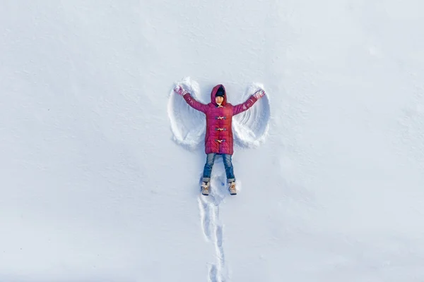 Fille montre ange de neige — Photo